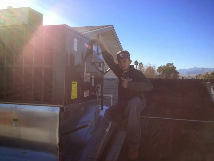 HVAC technician performing Air Duct Cleaning on a rooftop unit in Highland Village